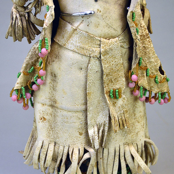 This antique Doll- Northern Plains Style offers exceptional handmade detail and strong visual presence. She stands approx. 14 inches tall. One of a Kind. The belt with a small beaded design.