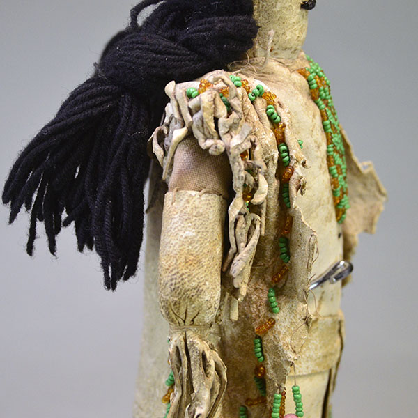 This antique Doll- Northern Plains Style offers exceptional handmade detail and strong visual presence. She stands approx. 14 inches tall. One of a Kind. The other side showcasing the beaded fringe.