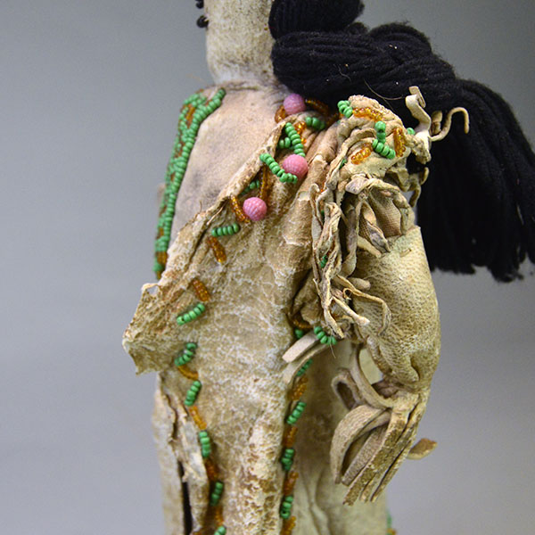 This antique Doll- Northern Plains Style offers exceptional handmade detail and strong visual presence. She stands approx. 14 inches tall. One of a Kind. The beaded fringe on the jacket.