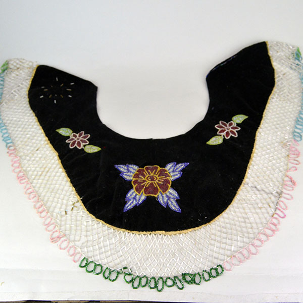 This floral beaded cape dates from the 1950s to 1960s and features an elaborate net fringe. few beads are missing, consistent with age and use.