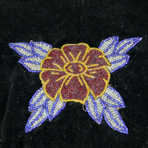 This floral beaded cape dates from the 1950s to 1960s and features an elaborate net fringe. few beads are missing, consistent with age and use. the other floral design.