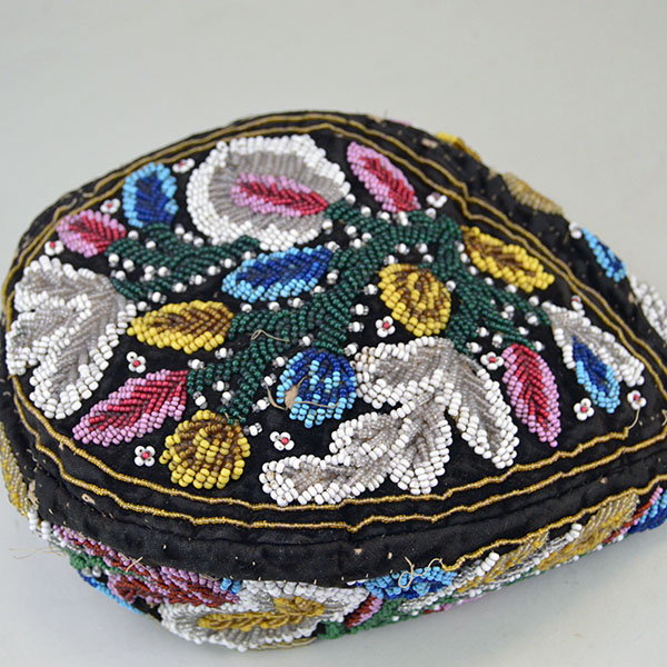 Antique Hat- Antique Beaded Glengarry, brown velveteen cap with a classic Iroquois‑style floral motif. hat shows wear, some bead loss. One of a Kind. The top view of the beaded design.