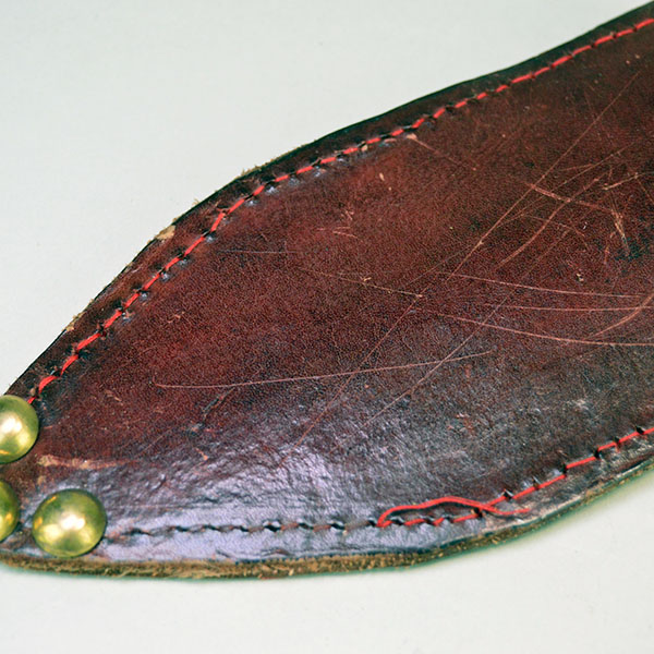 Knife- Beaver Tail Style with Decorative Brass‑Pinned Handle and Reinforced Leather Sheath. Approx. 7" double-edged Blade, and 5" handle . One of a Kind. The brass tacks on the tip of the sheath.