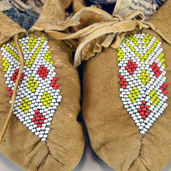 Moccasin- Child Center Seam, brick‑stitched the vamp in white, mustard yellow, and red‑orange. Like new , never worn, estimated child’s size 8–9. the brick design beaded on vamp.