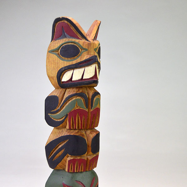 Hand‑carved Totem Pole 9" features a bear on top and a frog at the base. back is etched ‘L. Rudick,’ , is Larry Rudick is a Pacific Northwest carver. the bear
