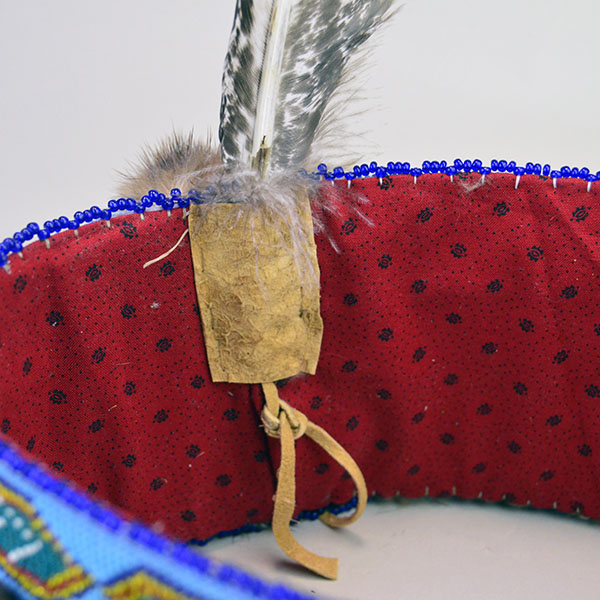 Striking Turban- Beaded with Otter will make a standout addition to your regalia. A vintage 1.5‑inch beaded strip on top, 23" in inside circumference. The flag holder and the fabric lining.