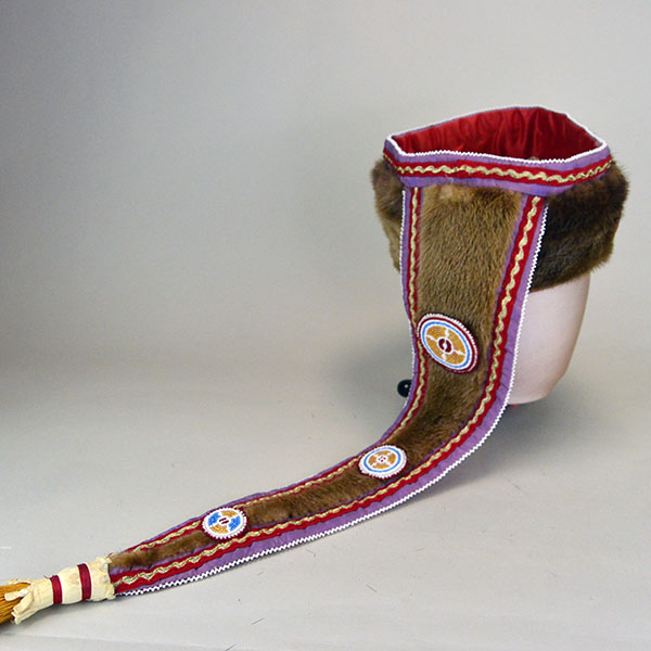 Turban Crafted in Otter Fur features six rosettes measuring between 1.25" x 2.5". approx. 21.5 inches inside circumference, drop measures about 24 inch". The back of the turban and the drop.