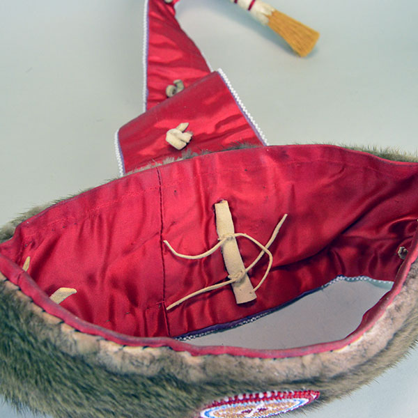 Turban Crafted in Otter Fur features six rosettes measuring between 1.25" x 2.5". approx. 21.5 inches inside circumference, drop measures about 24 inch". The inside where the crafter attached the drop and the red silk fabric lining.
