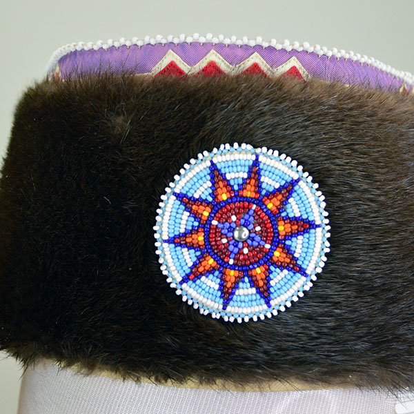 Turban- Handcrafted Otter fur features six rosettes. approximately 22 inches in inside circumference. The drop measures about 26 inches. one of a kind. The beaded rosette against the otter fur on the turban.