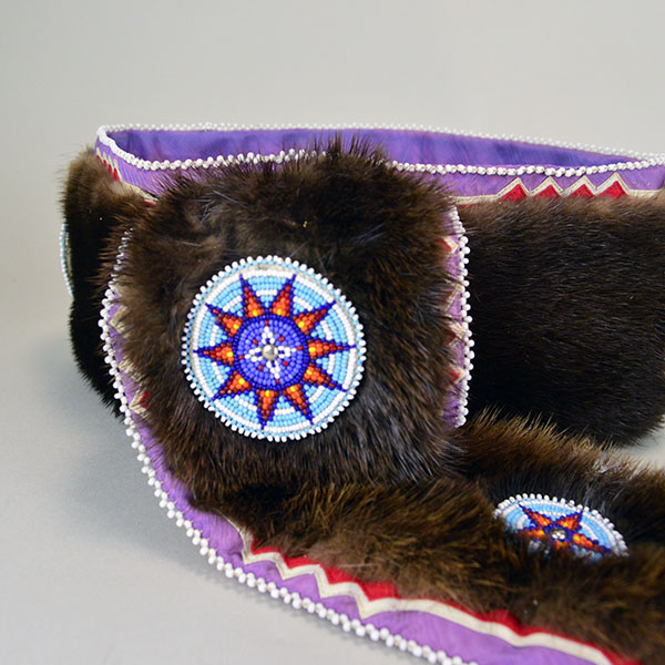 Turban- Handcrafted Otter fur features six rosettes. approximately 22 inches in inside circumference. The drop measures about 26 inches. one of a kind. The drop show casing a rosette and the ribbon work with the otter fur.