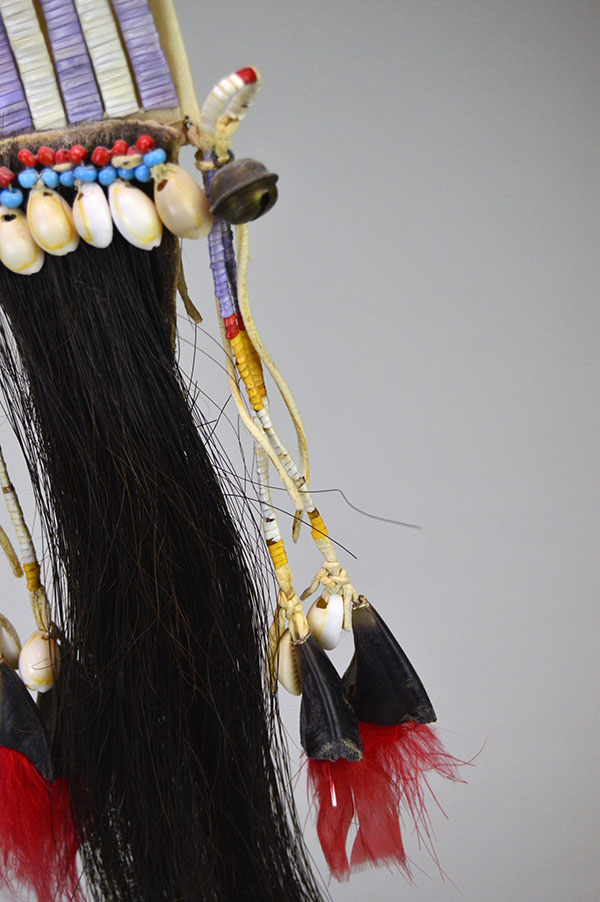 Wapegnaki- Hair Ornament Quilled features 9″ of quillwork on a 10″ rawhide base. Eight 5″ quilled tassels hang from the piece, 23″ dark horse‑hair drop. The bottom quilled drop.