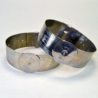 Handmade nickel silver armbands with stamped lines and diamond motifs; adjustable slide clips; approx. 1.25" wide x 14" long. One of a Kind.