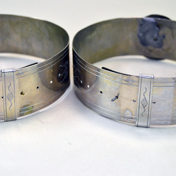 Handmade nickel silver armbands with stamped lines and diamond motifs; adjustable slide clips; approx. 1.25" wide x 14" long. One of a Kind. the back and inside.