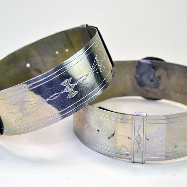 Handmade nickel silver armbands with stamped lines and diamond motifs; adjustable slide clips; approx. 1.25" wide x 14" long. One of a Kind. The design and the inside of the armbands.