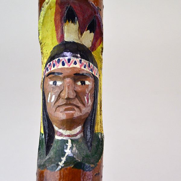 Vintage birch Cane- Indian Head & Leaves, approx. 36" long and 1.5" wide, featuring a hand‑chipped portrait, chipped leaf designs, hand‑painted details. The hand pained Indian head on the front of the cane.