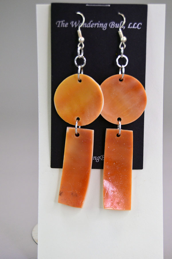 Orange Conch Shell double‑dangle earrings with drilled shell shapes, French hook ear wires, and handcrafted Wampanoag artistry by Devin Wixon. the back showcasing the beautiful orange color.