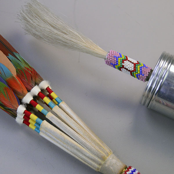 Handcrafted Gourd Dance Rattle Fan Set with bold beadwork, vibrant Macaw feathers, Ermine accents, and premium details for standout regalia.. The bead work at the top of the rattle and the thread work at the base of the feathers on the fan.