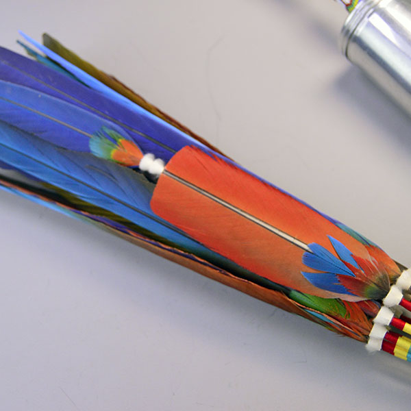 Handcrafted Gourd Dance Rattle Fan Set with bold beadwork, vibrant Macaw feathers, Ermine accents, and premium details for standout regalia.. Here is a picture of the cut down feather with the ermine fur and another color attached at the top.