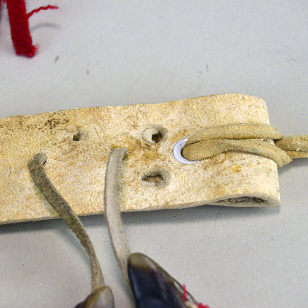 Handmade Deer Toe Leg Rattles on cream deerskin with red‑wool accents and traditional dance sound. They are approx. 14 inches long. one of a kind. The spot where you can add you own ties.