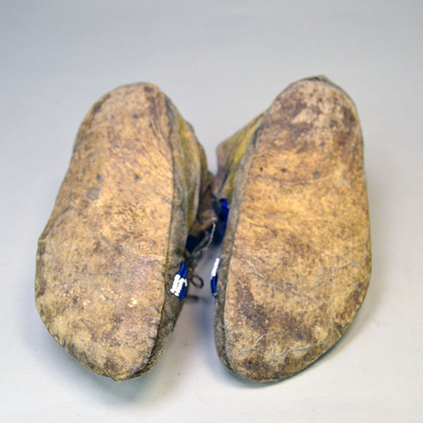 Antique Moccasins- Arapaho Style Child's with a bold cross design, intact 11/0 beadwork, Braintanned hide, rawhide sole, and early 1900s craftsmanship. pictured here is the rawhide soles.