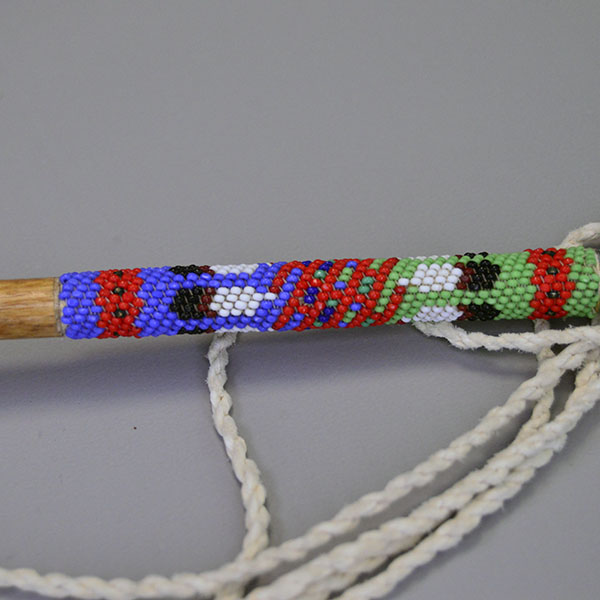 Dance Rattle Gourd- Beaded Handle with a real Bell Gourd, Peyote‑stitched beaded handle, twisted fringe, turquoise feathers, approx. 22.5 inches long. the beaded design on the bottom of the handle.