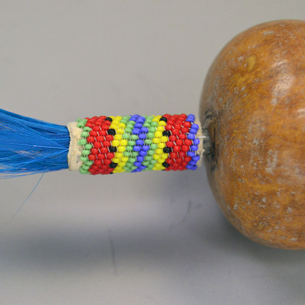 Dance Rattle Gourd- Beaded Handle with a real Bell Gourd, Peyote‑stitched beaded handle, twisted fringe, turquoise feathers, approx. 22.5 inches long. The top bead work design.