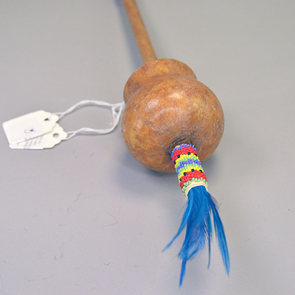 Dance Rattle Gourd- Beaded Handle with a real Bell Gourd, Peyote‑stitched beaded handle, twisted fringe, turquoise feathers, approx. 22.5 inches long. the top view showing the turquoise feathers against the beading.