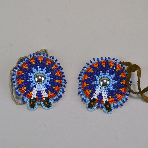 Seven‑piece Rosette Group Lot featuring matching sets, a pin rosette, Braintanned lacing, and dimensional edging. The lot offers mix of sizes. one of a kind. The front of the navy blue set.