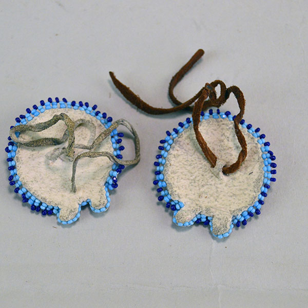Seven‑piece Rosette Group Lot featuring matching sets, a pin rosette, Braintanned lacing, and dimensional edging. The lot offers mix of sizes. one of a kind. The back of the third set.