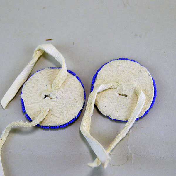 Seven‑piece Rosette Group Lot featuring matching sets, a pin rosette, Braintanned lacing, and dimensional edging. The lot offers mix of sizes. one of a kind. The back of the other set.