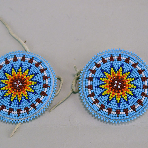 Seven‑piece Rosette Group Lot featuring matching sets, a pin rosette, Braintanned lacing, and dimensional edging. The lot offers mix of sizes. one of a kind. The front of the 3" rosettes.