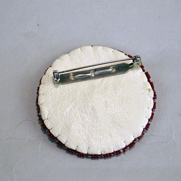 Seven‑piece Rosette Group Lot featuring matching sets, a pin rosette, Braintanned lacing, and dimensional edging. The lot offers mix of sizes. one of a kind. The back showing the pin rosette.