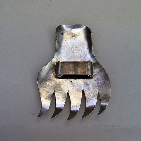 Vintage German silver Bear Paw scarf slide featuring stamped motifs and a soldered loop for easy threading. measures approximately 3.5″ long by 3″ wide. The back view.