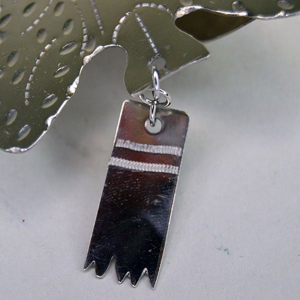 German silver Scarf Slide- Arrowhead with stamped designs and rectangular drop. Handmade piece in very good condition, measuring 4″ by 2.25″. Pictured here is the small drop and the stamped design.