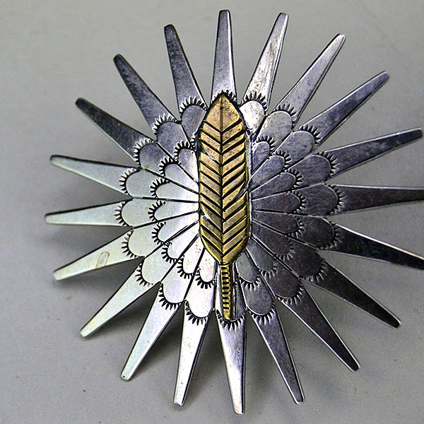 Pair Scarf Slide- Brass Feather hand‑stamped on German silver stars. Measures 2″ x 2″. Bold, compact accents for regalia, bandanas, and neckerchiefs. Pictured here is one of the brass stamped feathers.