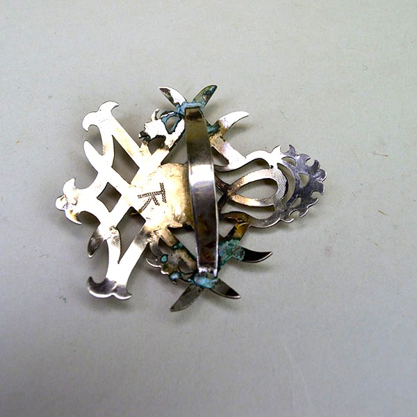 Scarf Slide- Double Strawberry with hand stapled brass concho, maker’s mark, and smooth soldered loop. Compact 2.5″ x 2.75″. here is a picture of the back with the attached metal loop for your scarf.