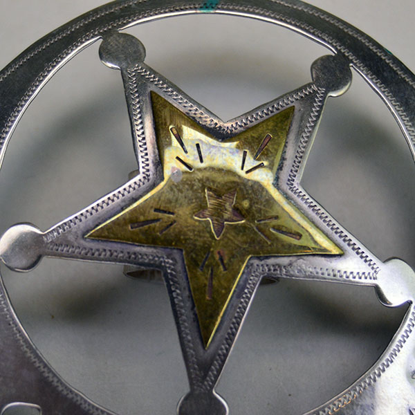 Handmade German silver Scarf Slide- Hearts & Stars, a brass accent, and a maker’s mark. Measures 3″ for bold regalia or everyday neckwear. Pictured here is the brass star and its hand stamped design .