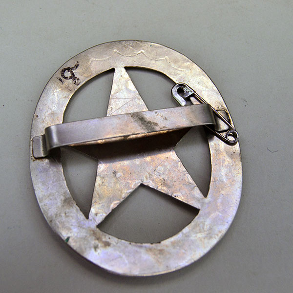 German silver Scarf Slide- Oval with Star with hand‑stamped designs and star cutout. Smooth loop for easy glide. Approx. 3" in diameter. Pictured here is the back showing the metal loop.