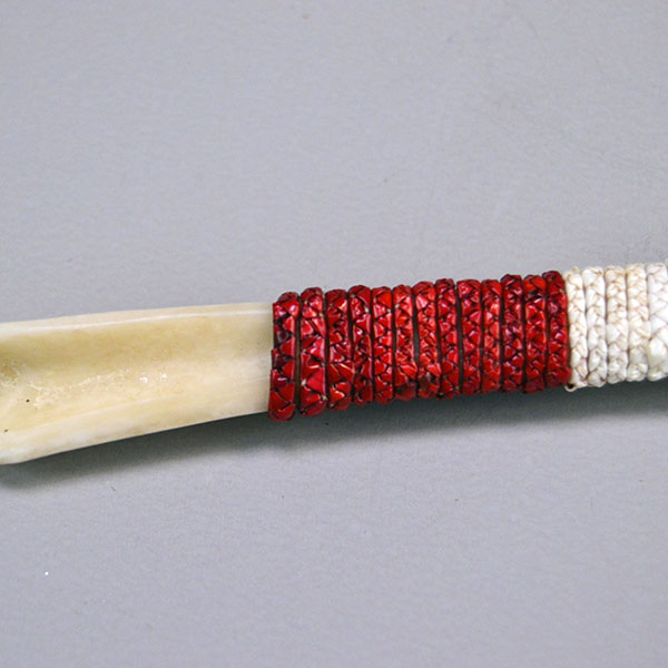 Hand‑quilled Awl- Deer Bone Quilled with red, white, and blue quillwork, secure sinew wrap, and protective leather cover. Approx. 6" long. One of a Kind. The top of the awl with the red braided quills.
