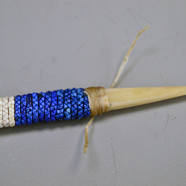 Hand‑quilled Awl- Deer Bone Quilled with red, white, and blue quillwork, secure sinew wrap, and protective leather cover. Approx. 6" long. One of a Kind. The end by the sharp point.