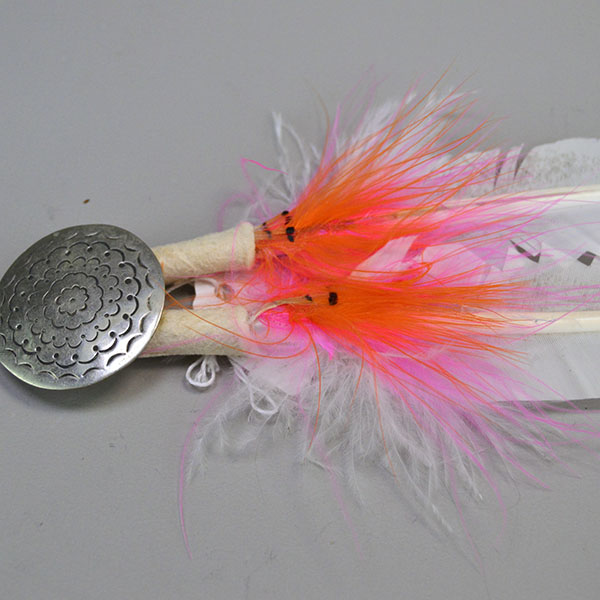 Scalp Feather- Stamped Concho, Hand‑painted scalp feather with a stamped concho, cut designs, pink fluffs, and traditional detailing. Measures 12.5 inches. Pictured here is the orange and pink fluffs with the hand stamped concho.