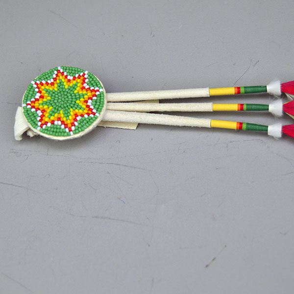 Scalp Feathers- 3 Green Macaw with a 1.25″ beaded rosette, leather wraps, thread accents, and ermine details. Measures 10″ overall. Pictured here is the beaded rosette showing how all the colors match the wrapped thread.