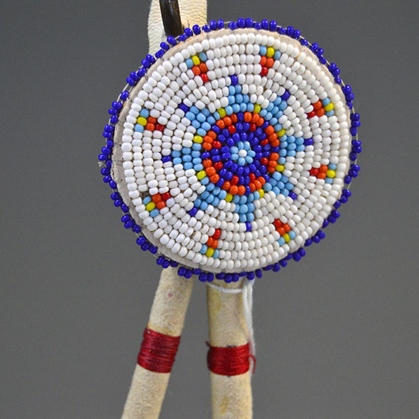 Hand‑painted turkey scalp feathers with a vibrant 11/0 beaded rosette, red accent tip, and deerskin wrapping for a balanced, traditional regalia finish. Pictured here is the beaded rosette with the star design.