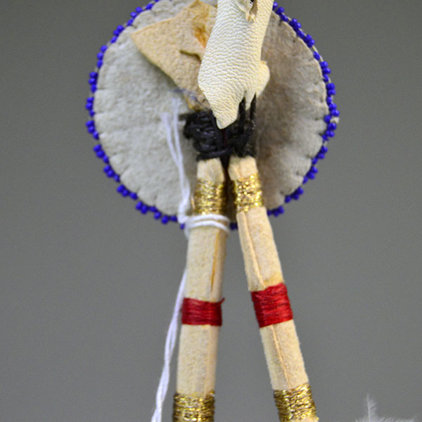 Hand‑painted turkey scalp feathers with a vibrant 11/0 beaded rosette, red accent tip, and deerskin wrapping for a balanced, traditional regalia finish. Pictured here is hot the crafter attached the rosette to the feathers.