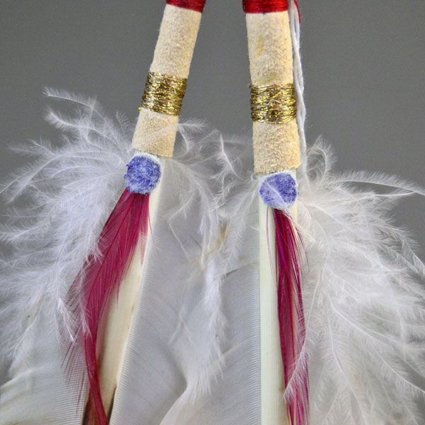 Hand‑painted turkey scalp feathers with a vibrant 11/0 beaded rosette, red accent tip, and deerskin wrapping for a balanced, traditional regalia finish. Pictured here is the thread wrapped over the white leather at the bottom.