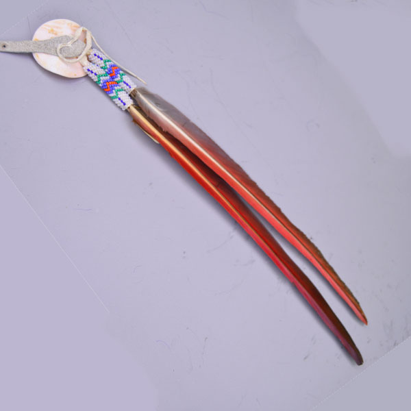 This striking Blue Macaw Scalp Feather & Conch blends bold natural feathers with detailed beadwork and traditional beadwork. Pictured here is the back view.