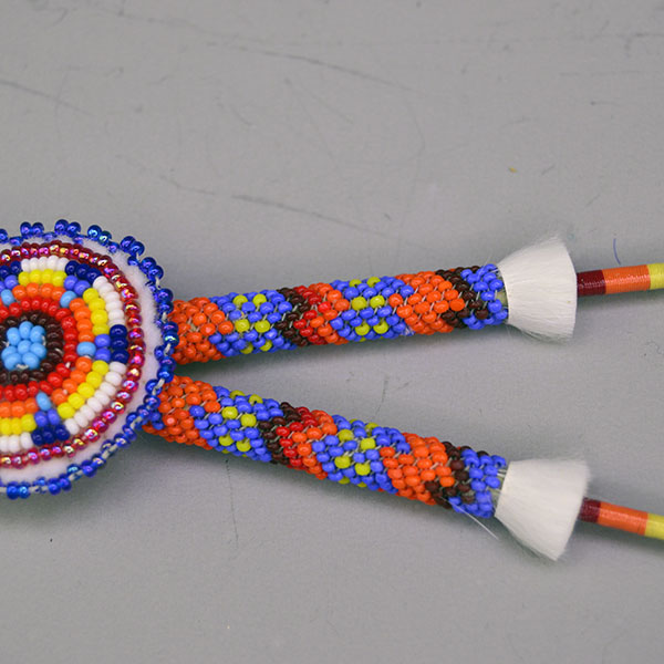 Scalp Feathers- Peyote Stitch with a 1.5″ beaded rosette, 2″ peyote stitch, thread wraps, ermine accents. Feathers measure 7″; full piece measures 12″. Pictured here is the beaded rosette and the peyote stitch with the matching colors.