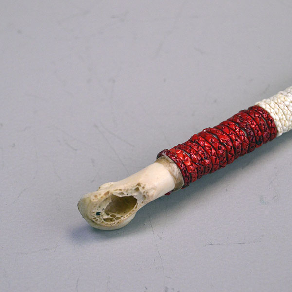 Whistle- Bird Wing Bone Quilled with braided red, white, and blue porcupine‑quillwork and a secure sinew wrap. Approx. 5.5 inches long. One of a kind. the start of the red quill work.