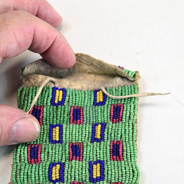 Antique Bag- Strike a Lite Beaded, smoked Braintanned leather, trans cobalt, greasy yellow, white center red. Measures approx. 4" × 3". one of a kind. Pictured is the opening and the flap.