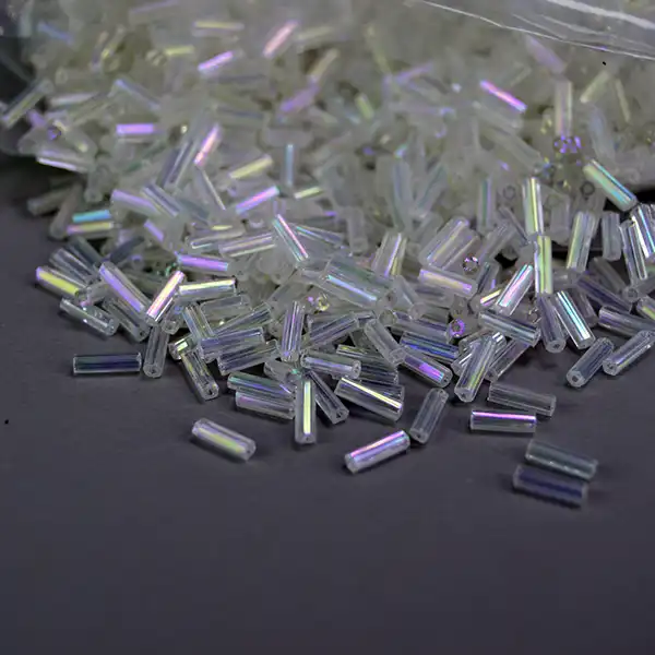 Shop 18 oz of Bead Lot- Iridescent White Bugle beads. Perfect for beadwork, fringe, regalia, jewelry making, and craft projects that shine. 7 mm long. Here is a different view.